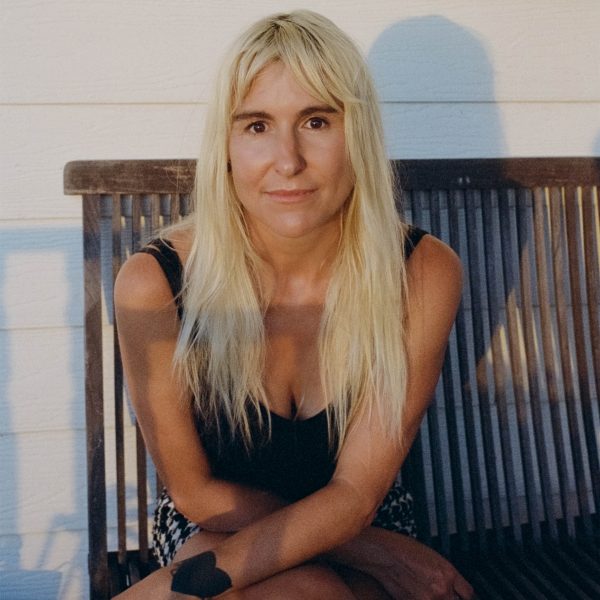 Briohny Doyle Author Photo - A blonde-hair woman sitting in a chair