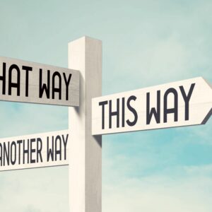 A white timber signpost against a blue sky, with arrows saying "THAT WAY", "THIS WAY" and "ANOTHER WAY" all pointing in different directions.